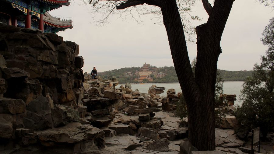 The golden-roofed Tower of Buddhist Incense rising above autumn foliage on Longevity Hill at Beijing's Summer Palace, seen across Kunming Lake from South Lake Island