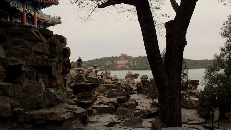 The golden-roofed Tower of Buddhist Incense rising above autumn foliage on Longevity Hill at Beijing's Summer Palace, seen across Kunming Lake from South Lake Island