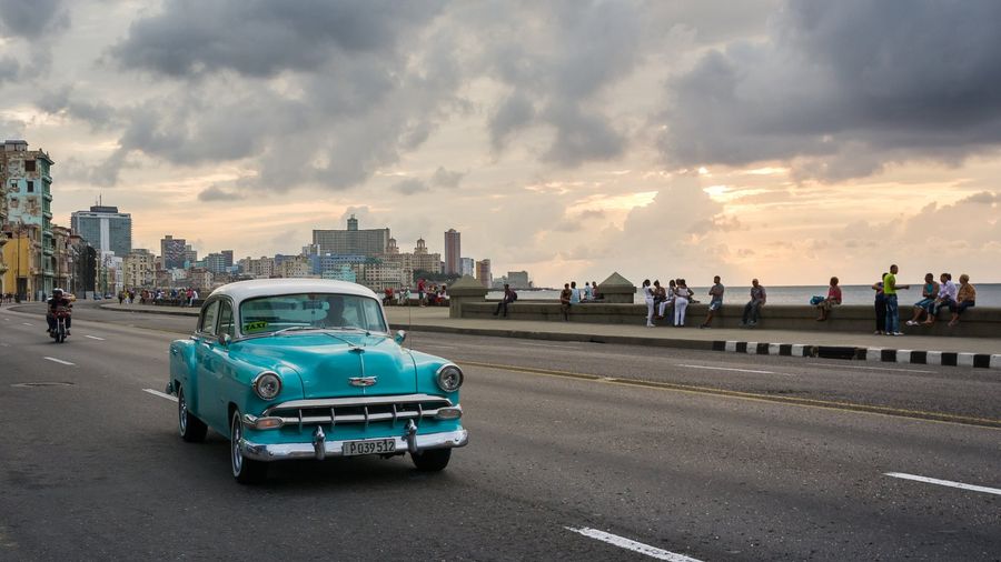 A classic 1950s American convertible car parked along the Malecón seafront in Havana, Cuba, used as a tourist taxi