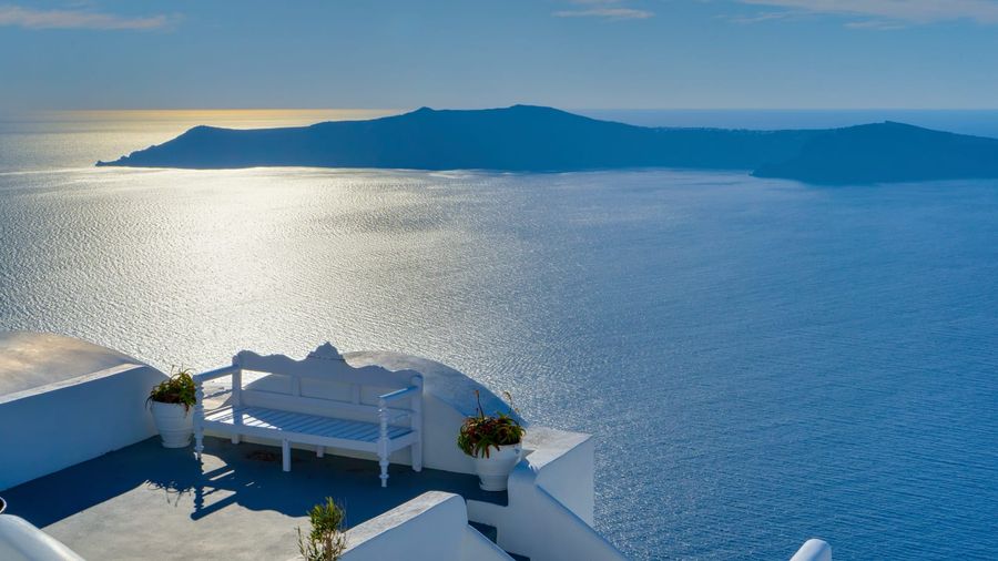 Whitewashed houses and blue-domed churches of Oia cascading down the volcanic caldera cliffs of Santorini above the deep-blue Aegean Sea
