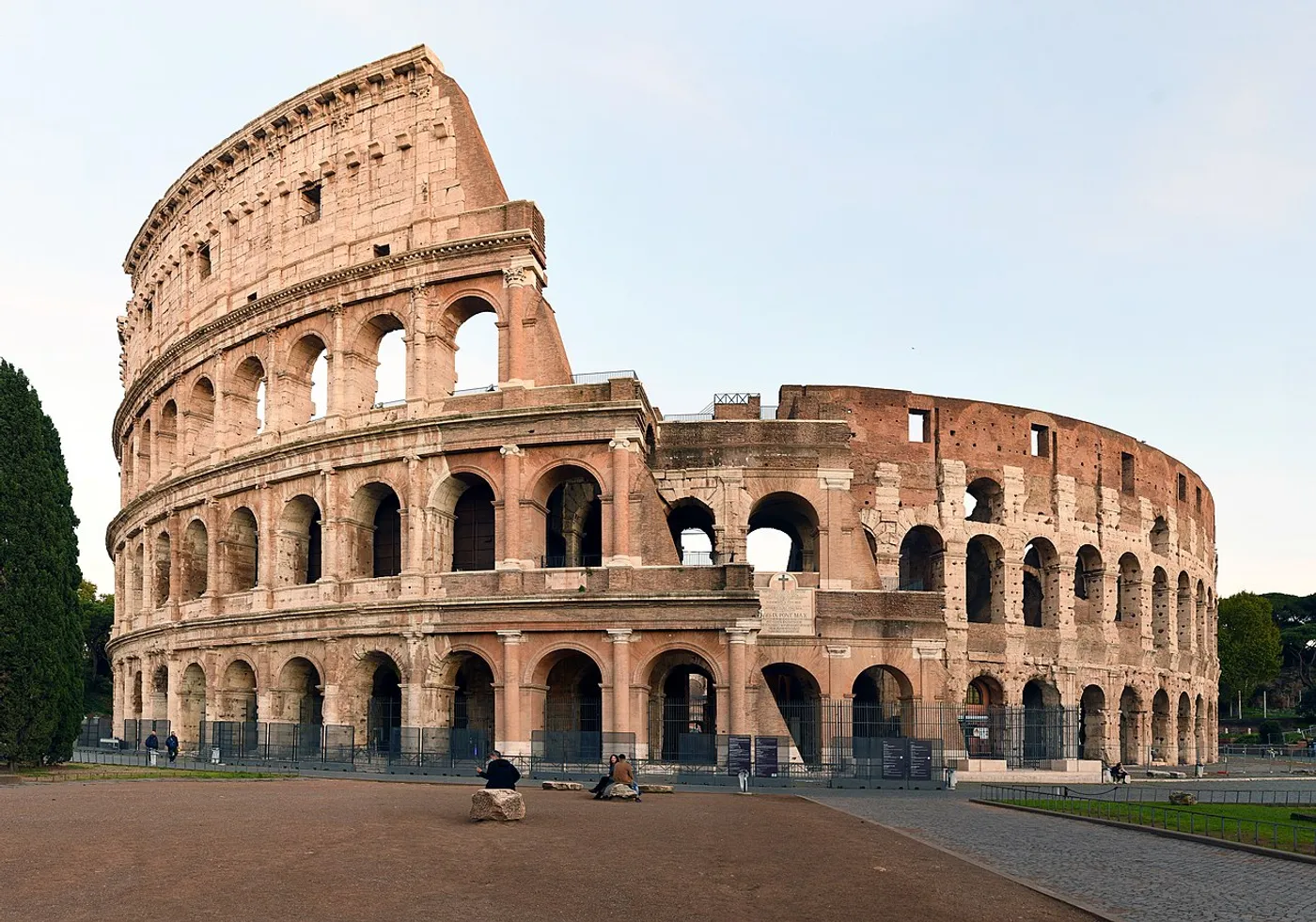 Photo of the Colosseum in Rome under a golden sky.